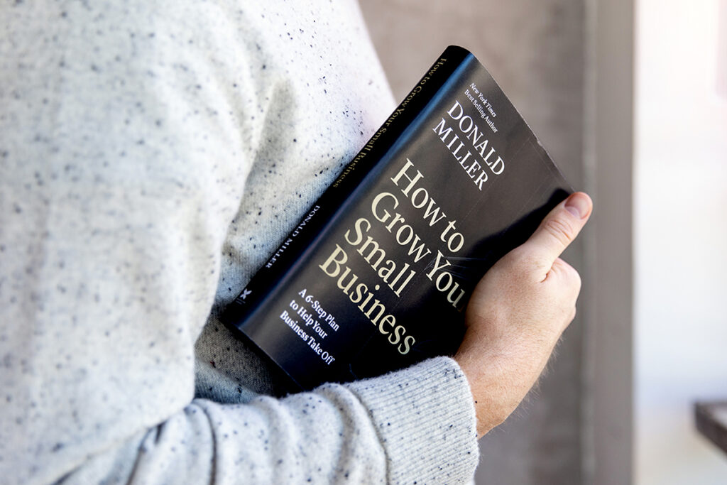 Man holding a copy of How to Grow Your Small Business