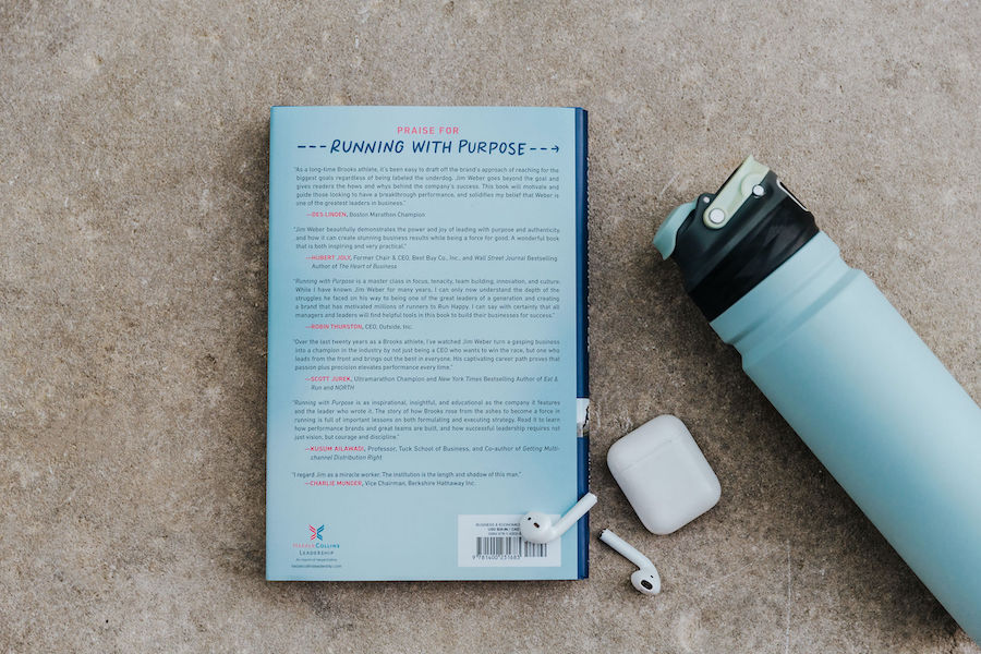 Running with Purpose upside down next to a water bottle and earbuds
