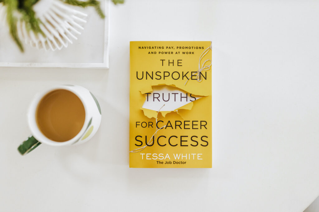 Copy of "The Unspoken Truths for Career Success" on a table with a coffee mug