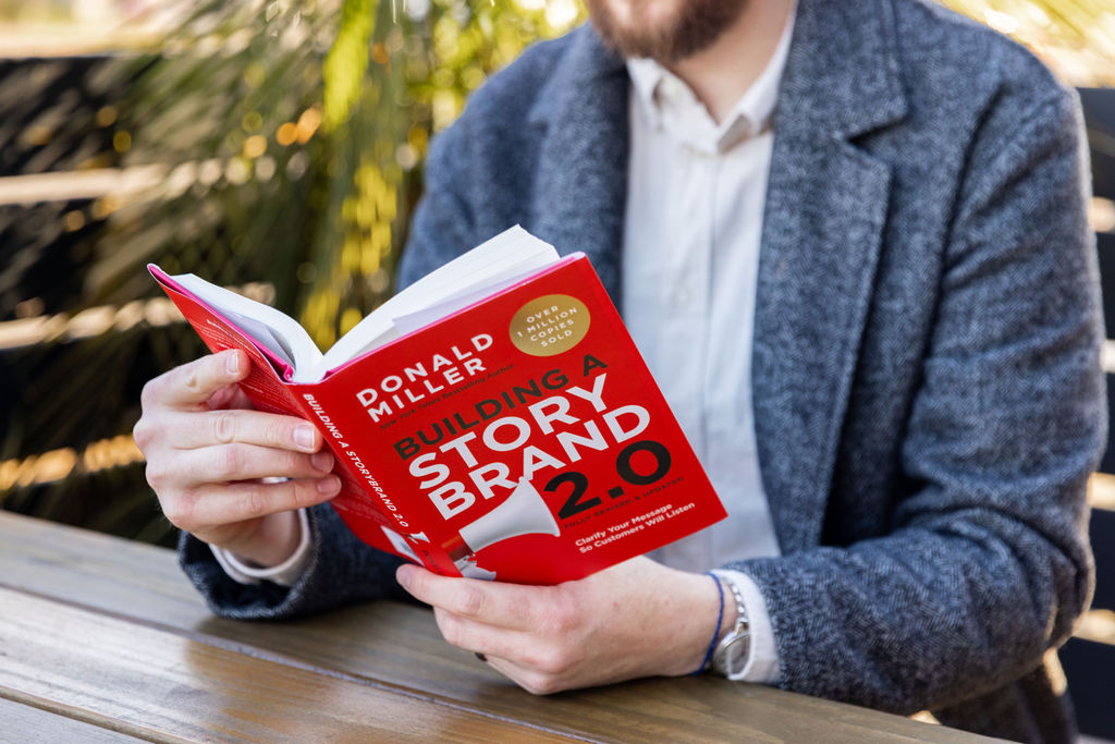 A man reading "Building a StoryBrand 2.0"